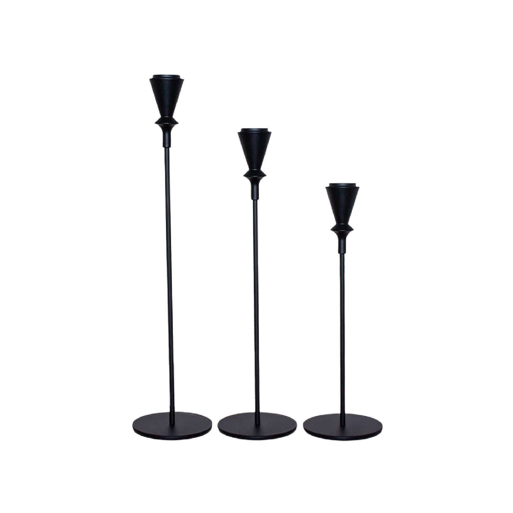 Set of three black metal candlesticks in varying heights