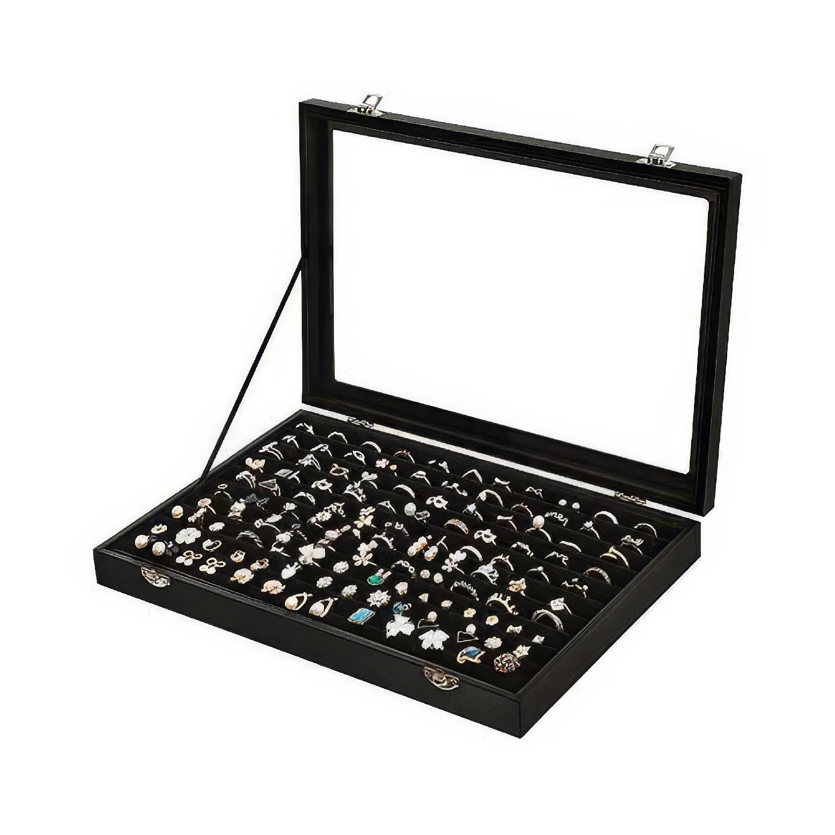 Black ring display case with clear glass lid showcasing assorted rings and jewellery pieces