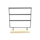 Black metal earring holder with three rows on a natural wood base