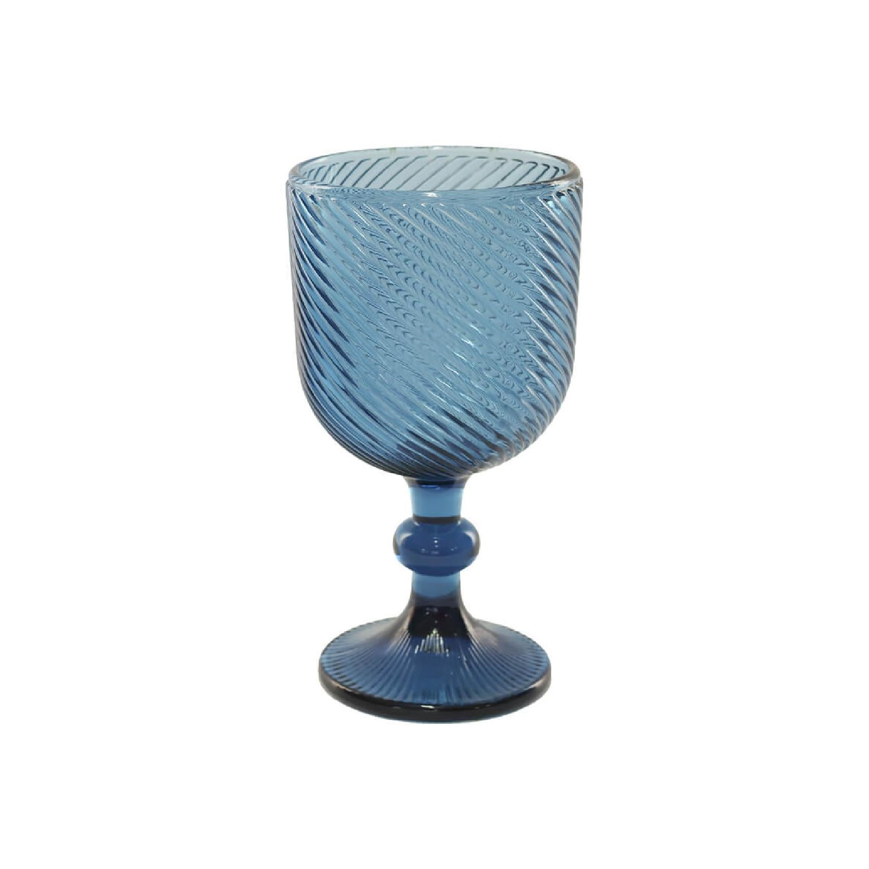 Blue glass goblet with textured design on a white background