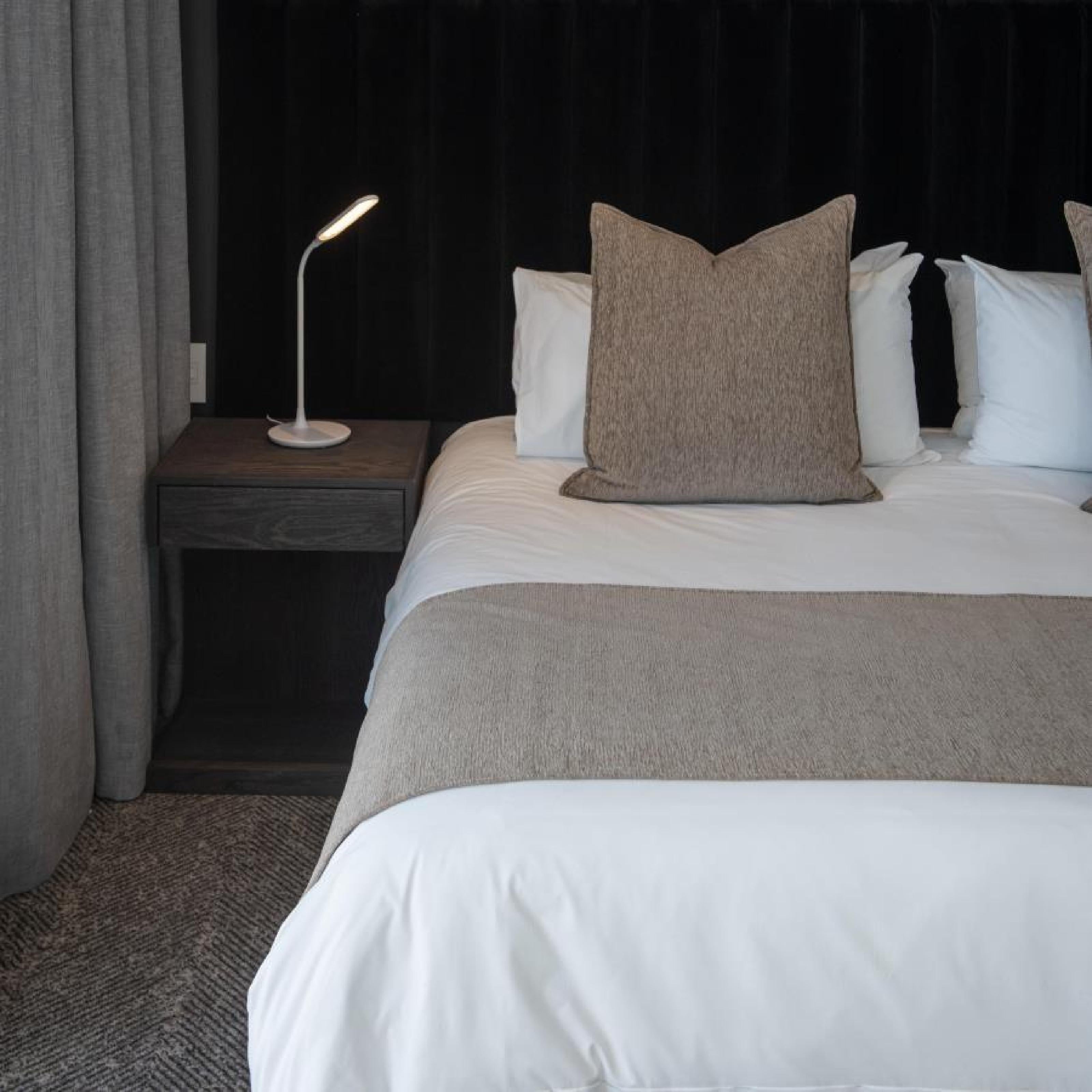 Cobblestone coloured scatter cushion styled on white bedding