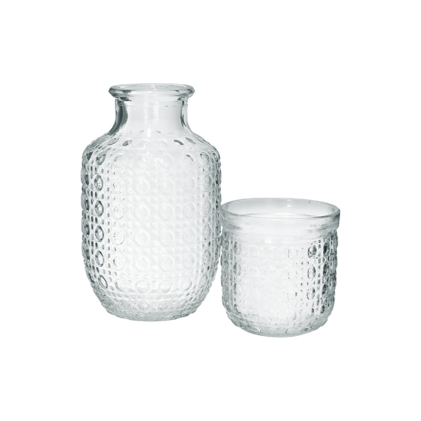 Clear embossed glass carafe and tumbler set on a white background