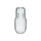 Clear embossed glass carafe and tumbler set on a white background