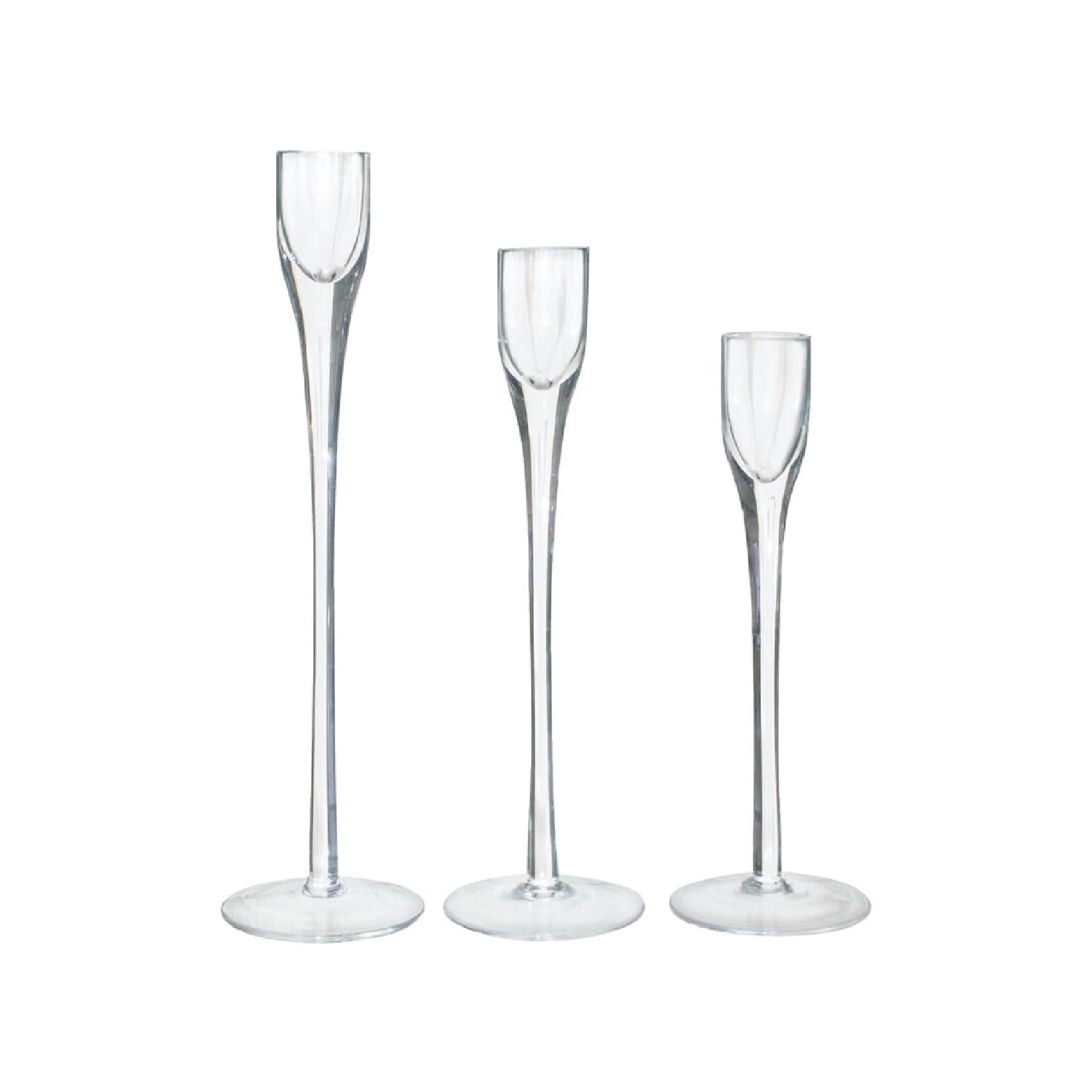 Three clear glass candlesticks with varying heights