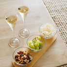 Nova champagne flutes styled on a table with fruit, nuts & popcorn for entertaining