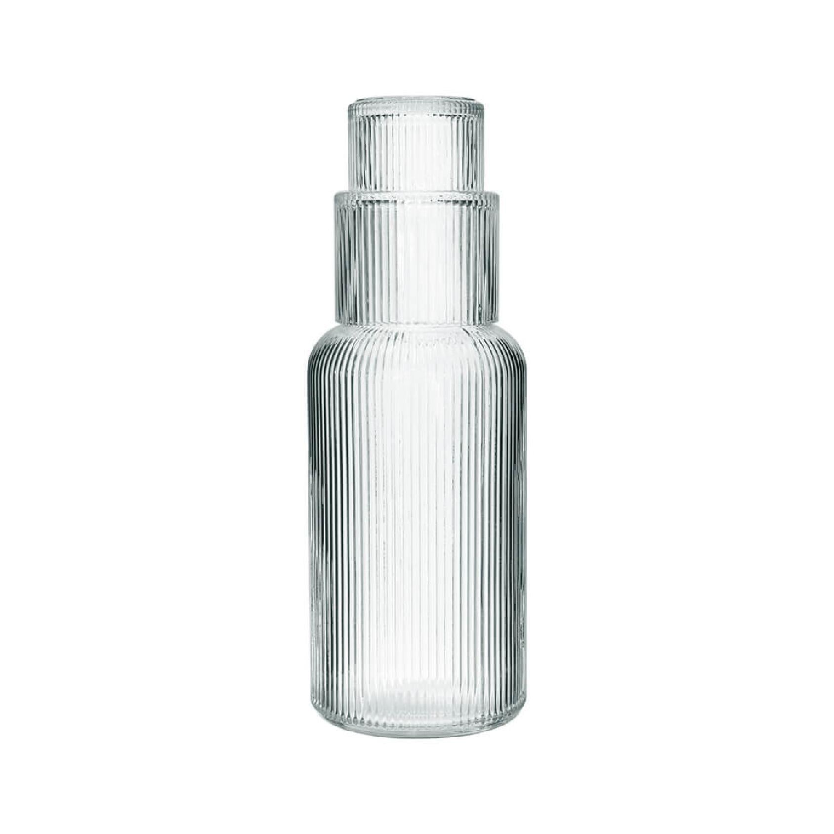 Clear ribbed glass carafe and tumbler on a white background