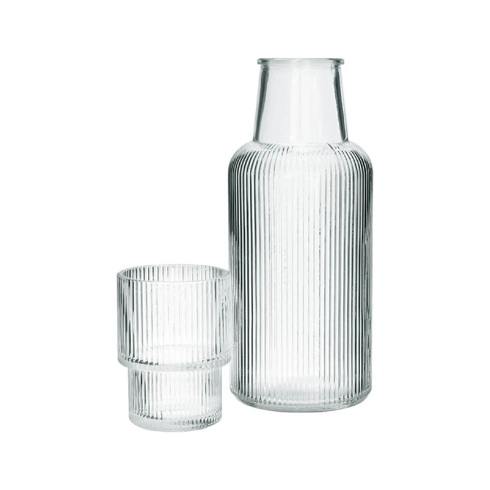 Clear ribbed glass carafe and tumbler on a white background