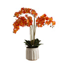 Artificial orange orchid in a beige ceramic pot