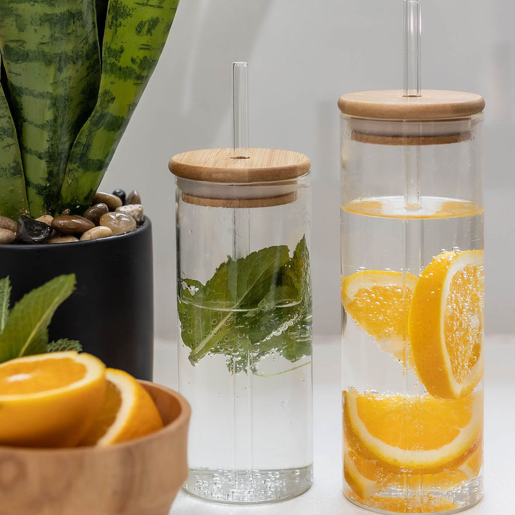 Glass drinking bottle with a bamboo lid and a glass straw