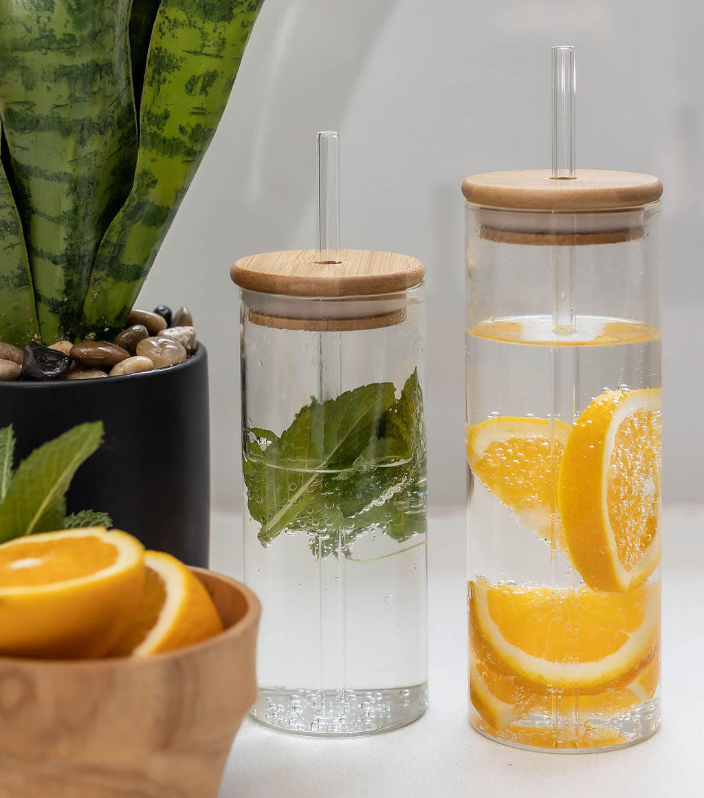 Glass drinking bottle with a bamboo lid and a glass straw