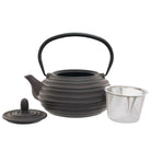 A dark brown cast iron teapot with circular ridges on the body, a black metal handle and a stainless steel mesh infuser