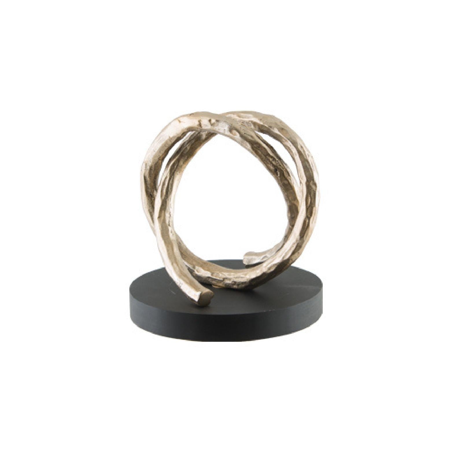 Circular gold sculpture on a black wooden base