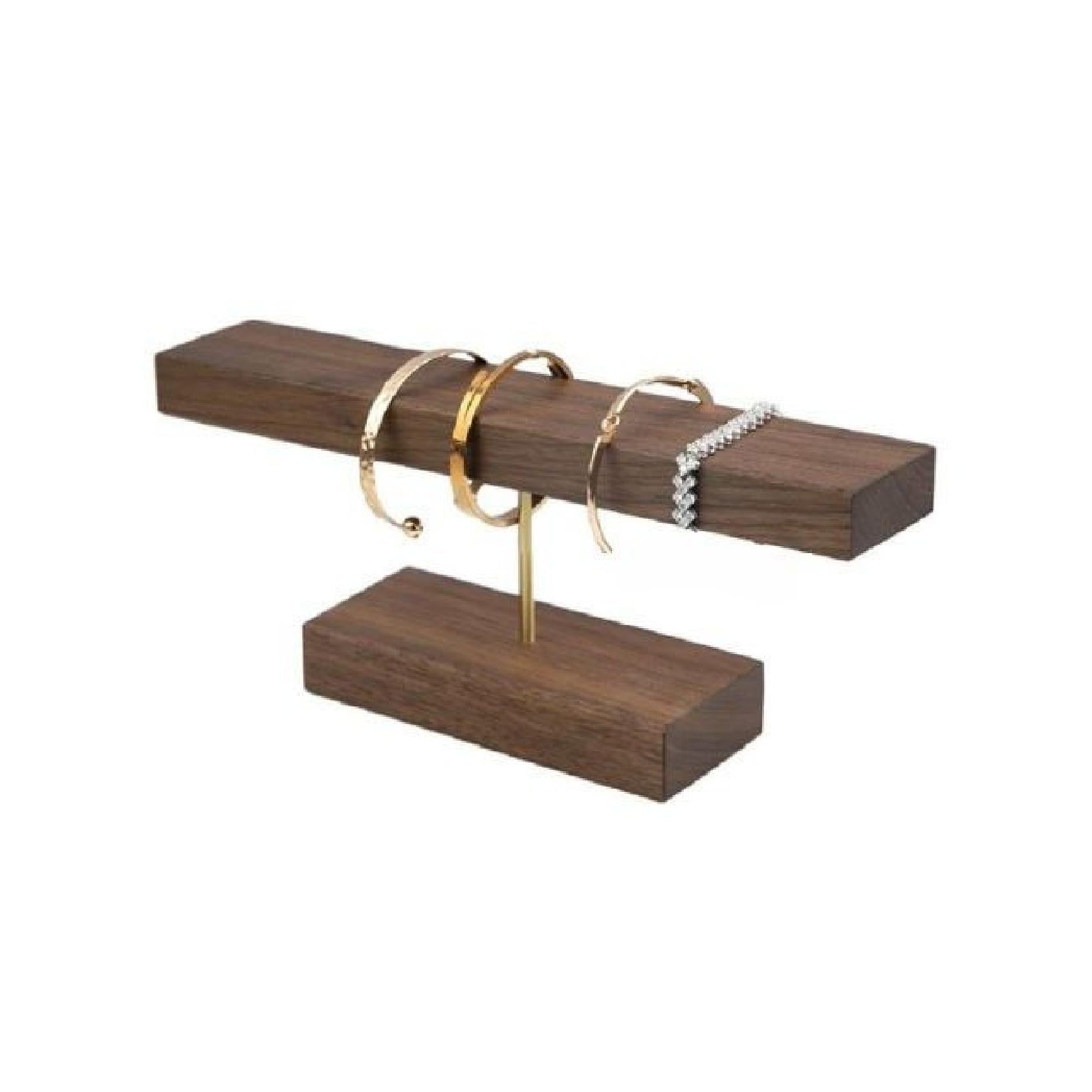 Bracelets styled on a dark wood square bracelet display bar with a gold metal bar