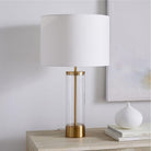 Table lamp with a white shade and a gold base styled on a sideboard