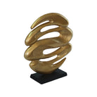 Gold abstract sculpture on a black base against a white background