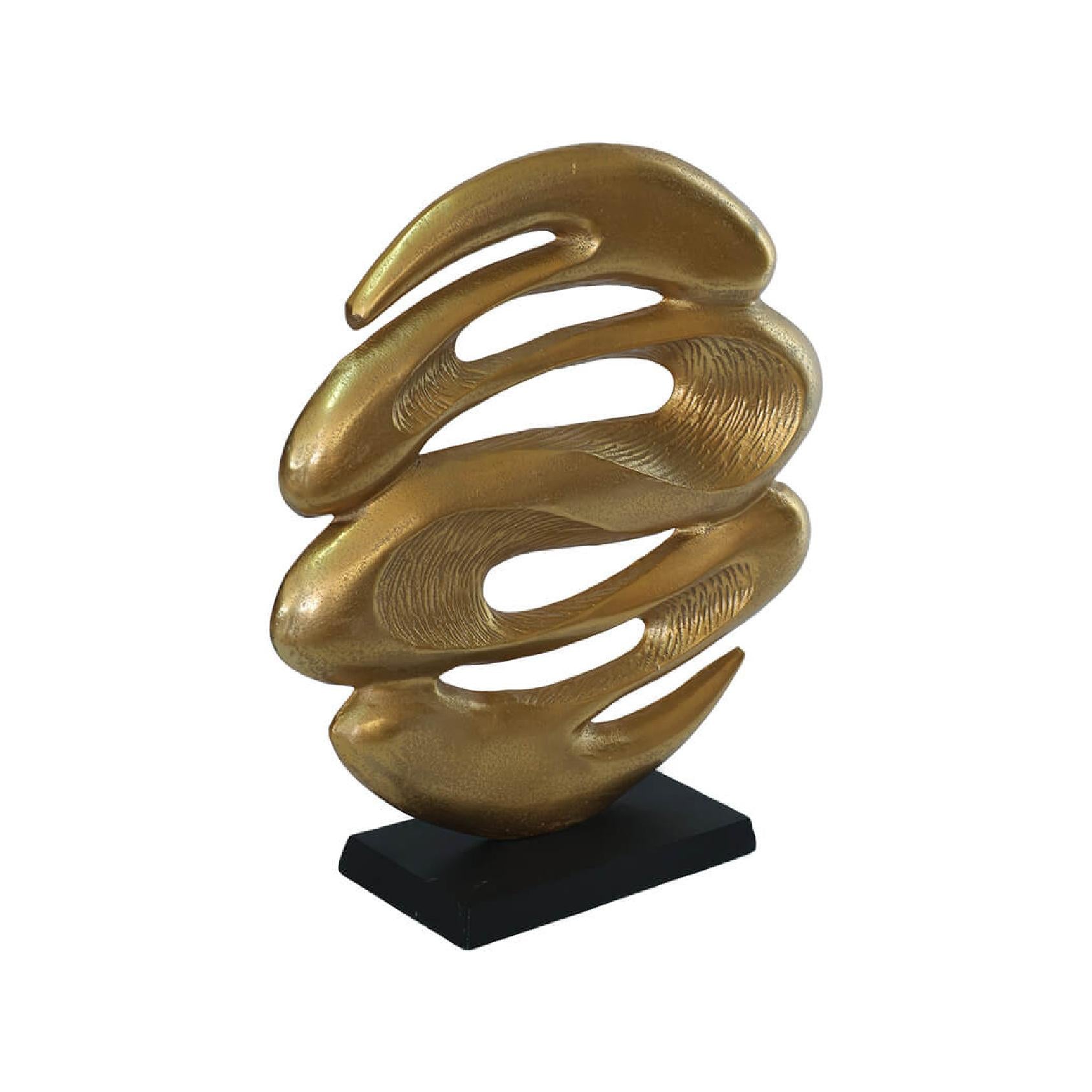 Gold abstract sculpture on a black base against a white background