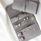 Close-up of grey jewellery roll interior with rings, earrings and studs