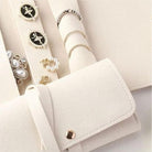 Close-up of ivory jewellery roll interior with rings, earrings and studs