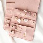 Close-up of pink jewellery roll interior with rings, earrings and studs