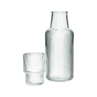 Clear ribbed glass carafe and tumbler on a white background
