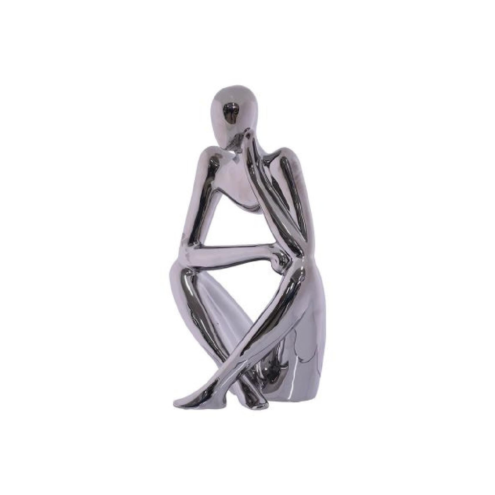 Silver metallic sculpture of a sitting figure